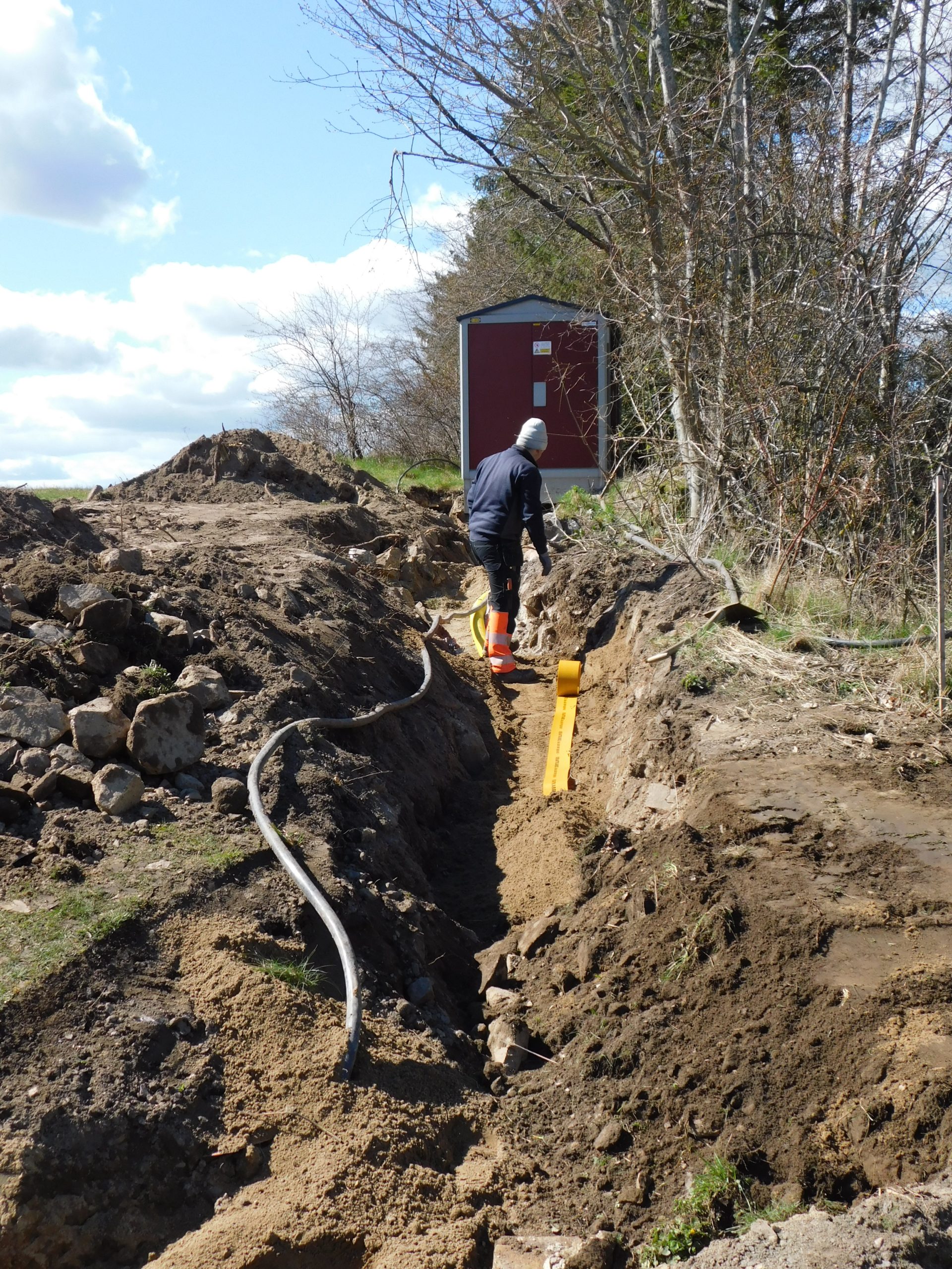 Ett grävt schakt där de lägger ner en ny elkabel.